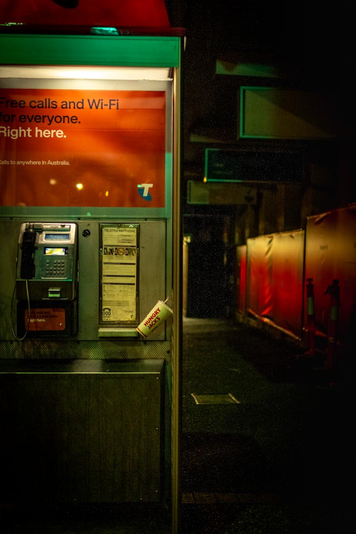 Crafting Captivating Headlines: Your awesome post title goes here Night view of an illuminated phone booth in Brisbane City, Australia, showcasing urban ambiance.
